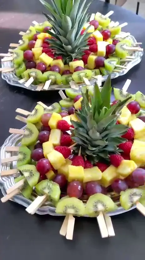 Brochettes de fruits disposées en couronne autour d’un ananas