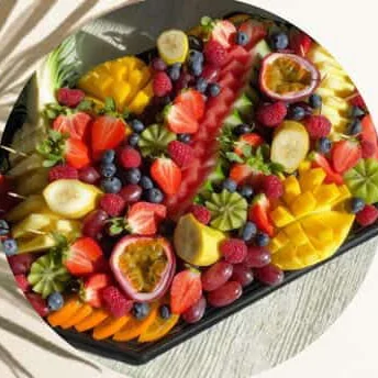 Plateau de fruits : fraises, myrtilles, fruits de la passion, mangue et kiwis