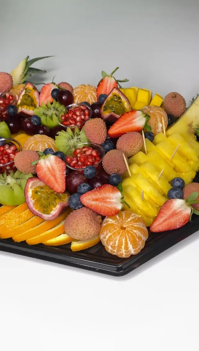 Plateau garni de fruits exotiques, ananas et oranges en tranches