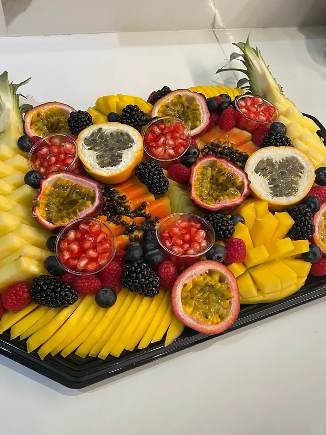 Plateau de fruits de la passion, grenadilles, papaye, mangue et grenade en coupelles