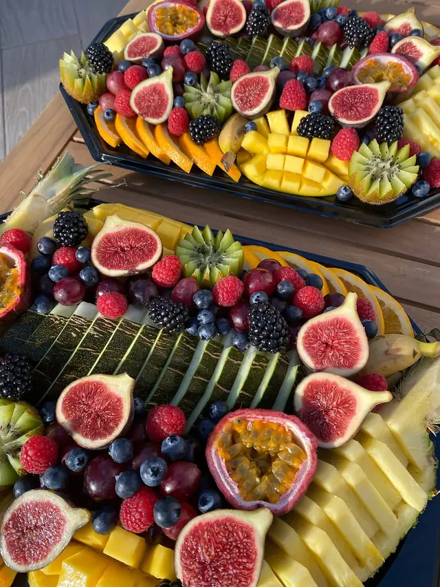 Plateaux de figues, melon, framboises et mangue en damier dans la lumière du soir