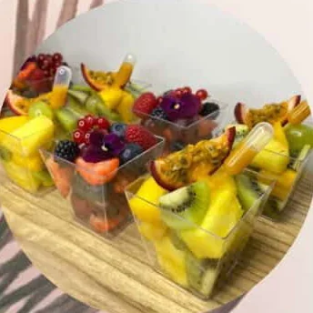 Verrines de fruits frais avec fleurs et pipettes de fruit de la passion